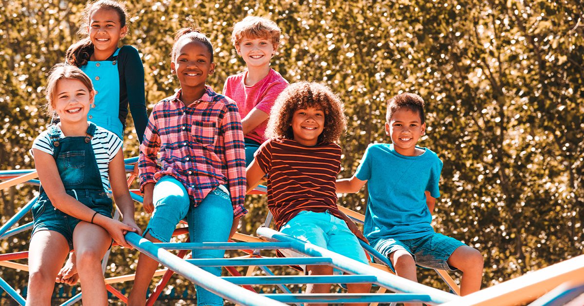 group of kids smiling on the playground set