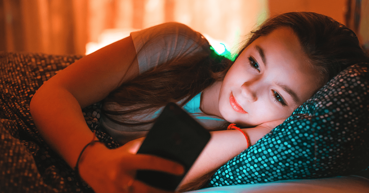 girl on phone while laying in bed