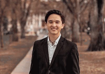 person wearing a suit, smiling outside